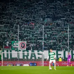 Tysiące kibiców Lechii Gdańsk z szalikami, mimo ujemnych punktów, tworzy zielono-białą ścianę.