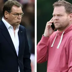 Jan Urban i jego syn, jeden w garniturze, drugi w bluzie, rozmawiają przez telefon.