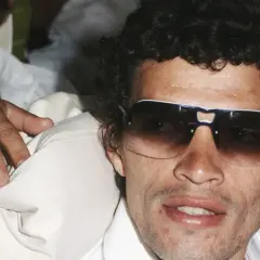 Santana, trener piłkarski, w okularach przeciwsłonecznych, z ręką na ramieniu.