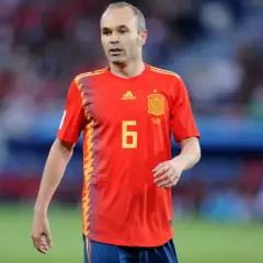Hiszpański piłkarz Andres Iniesta w czerwonej koszulce z numerem 6 na boisku.