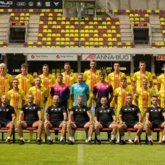 Drużyna Korona Kielce zawodnicy pozują do zdjęcia na tle stadionu.