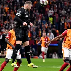 Piłkarz Juventusu skacze do piłki w meczu Ligi Mistrzów. Ile razy Juventus wygrał Ligę Mistrzów? Dwa razy.