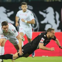Piłkarz w czarnym stroju upada, próbując ratować piłkę. Czy można dobijać rzut karny w takiej sytuacji?