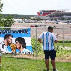Fani Argentyny podziwiają baner z wizerunkami Messiego i Diego Maradony, wspominając jego statystyki i legendę.