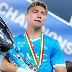 Młody środkowy napastnik z pucharem w rękach, dumny z wygranej.