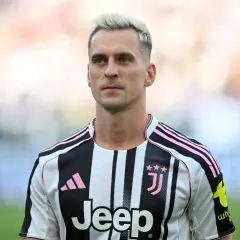 Piłkarz Arkadiusz Milik w koszulce Juventusu z różowymi pasami.