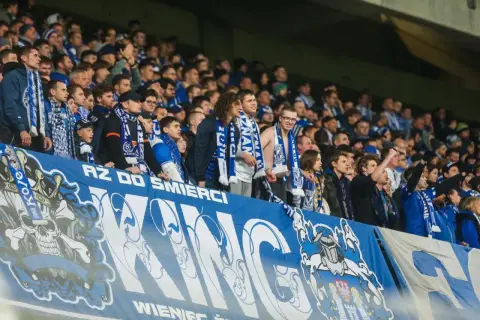 Kibice Lecha Poznań na europejskie puchary, z szalikami i transparentem "AZ DO ŚMIERCI".