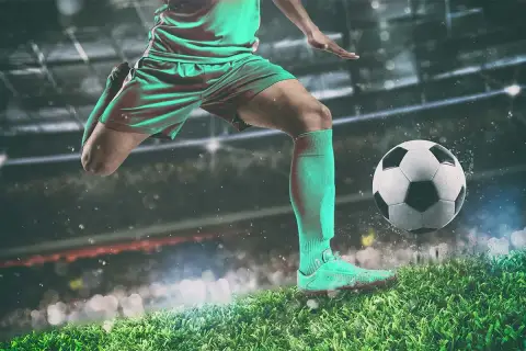 Piłkarz w akcji, gotowy do strzału. W tle stadion, gdzie rodzą się legendy piłki nożnej.
