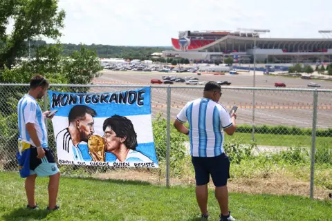 Fani Argentyny podziwiają baner z wizerunkami Messiego i Diego Maradony, wspominając jego statystyki i legendę.