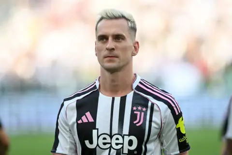 Piłkarz Arkadiusz Milik w koszulce Juventusu z różowymi pasami.