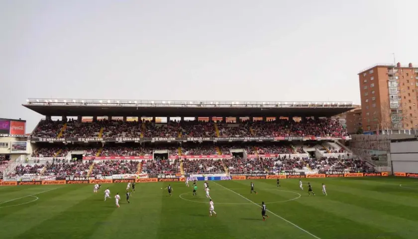 Mecz na madryckim stadionie. Piłkarze biegają po zielonej murawie, a trybuny wypełniają kibice.
