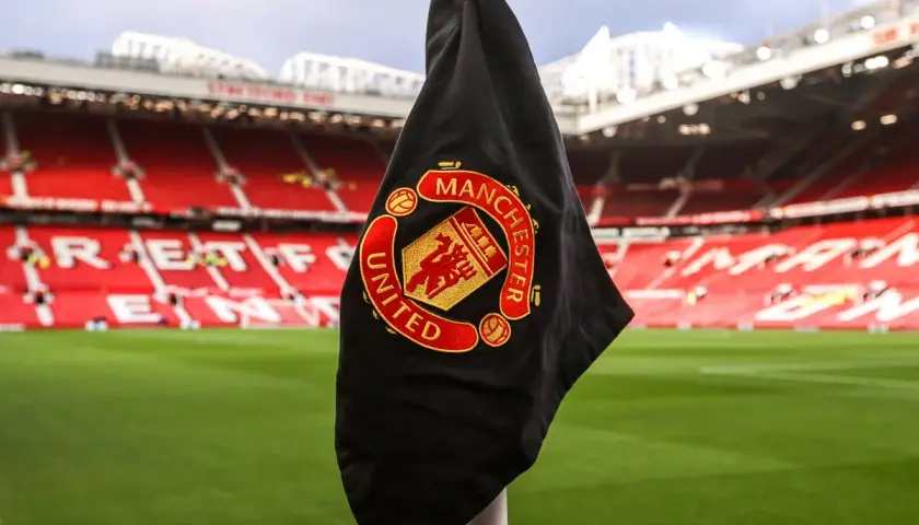 Flaga Manchester United na rogu boiska. Fani spekulują o nowych transferach, a Old Trafford czeka na wzmocnienia.
