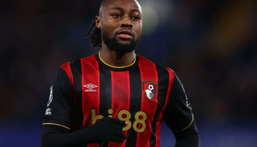 Piłkarz w koszulce Bournemouth z numerem 38, z uwagą śledzi rozwój wydarzeń na boisku, jakby czekał na swoje okno transferowe.