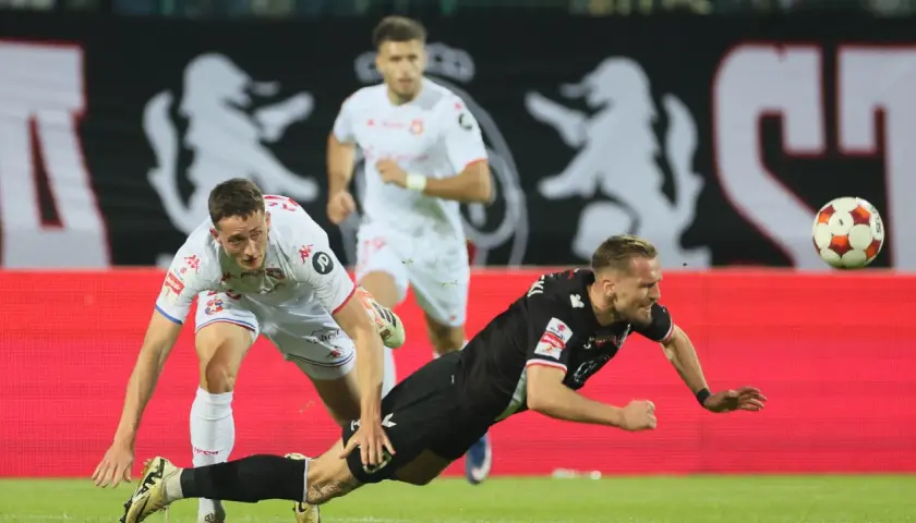 Piłkarz w czarnym stroju upada, próbując ratować piłkę. Czy można dobijać rzut karny w takiej sytuacji?