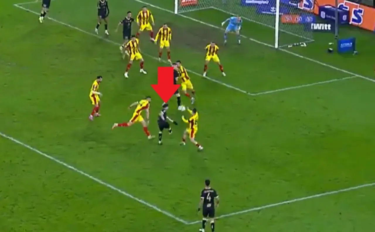Intensywna akcja w meczu Pogoń Szczecin – Korona Kielce. Piłkarz w czarnym stroju próbuje odebrać piłkę zawodnikowi w żółto-czerwonych barwach.
