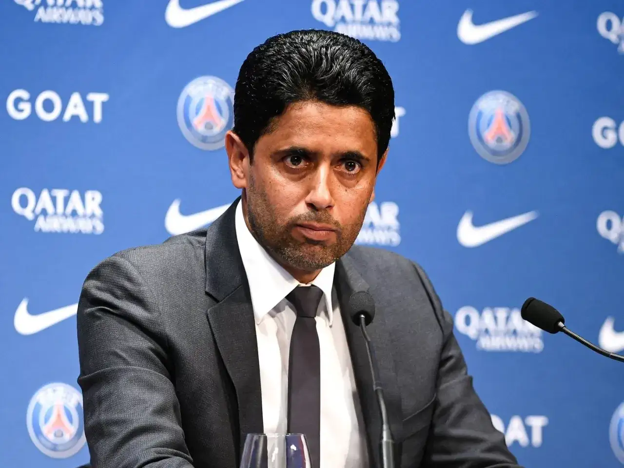 Nasser Al-Khelaifi, właściciel PSG, podczas konferencji prasowej. Tło zdobią loga Qatar Airways i Nike.