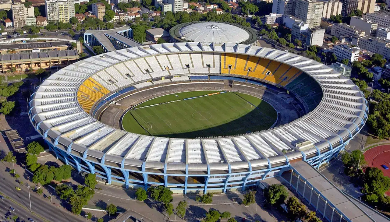 Widok z lotu ptaka na stadion Marakana w Rio de Janeiro, z zieloną murawą i żółto-białymi trybunami.