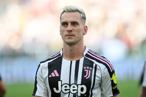 Piłkarz Arkadiusz Milik w koszulce Juventusu z różowymi pasami.